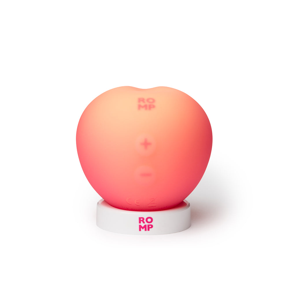 Romp Pink Peach Air Suction Clitoral Stimulator in playful peach design on white base.