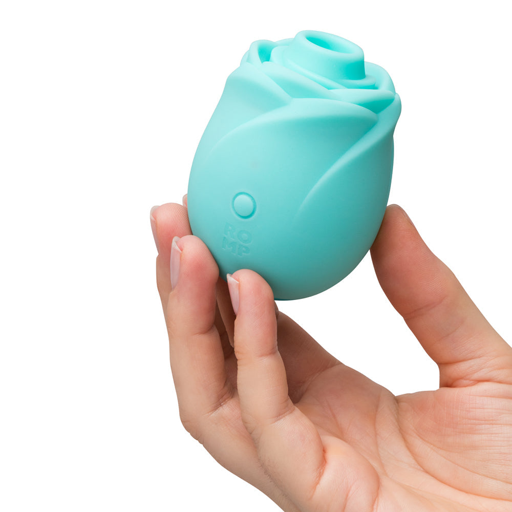 Romp Glow Air Suction Rose Massager held in hand, showcasing its elegant rose design and silicone texture.