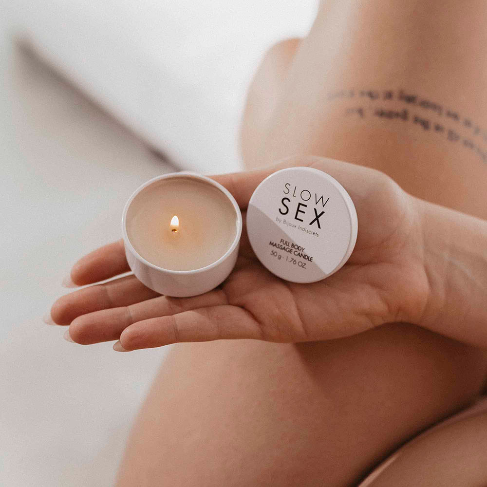Bijoux Indiscrets Slow Sex Massage Candle in hand, ready for a sensual massage experience.