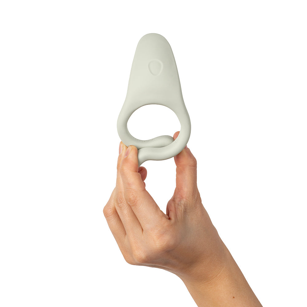 Dame Hug Vibrating Couples Ring Fog held by a hand, showcasing its soft and flexible design for partner play.