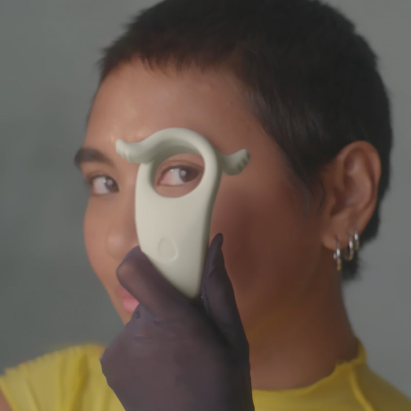 Dame Hug Vibrating Couples Ring Fog held by a person with short hair and gloves, showcasing its unique design.
