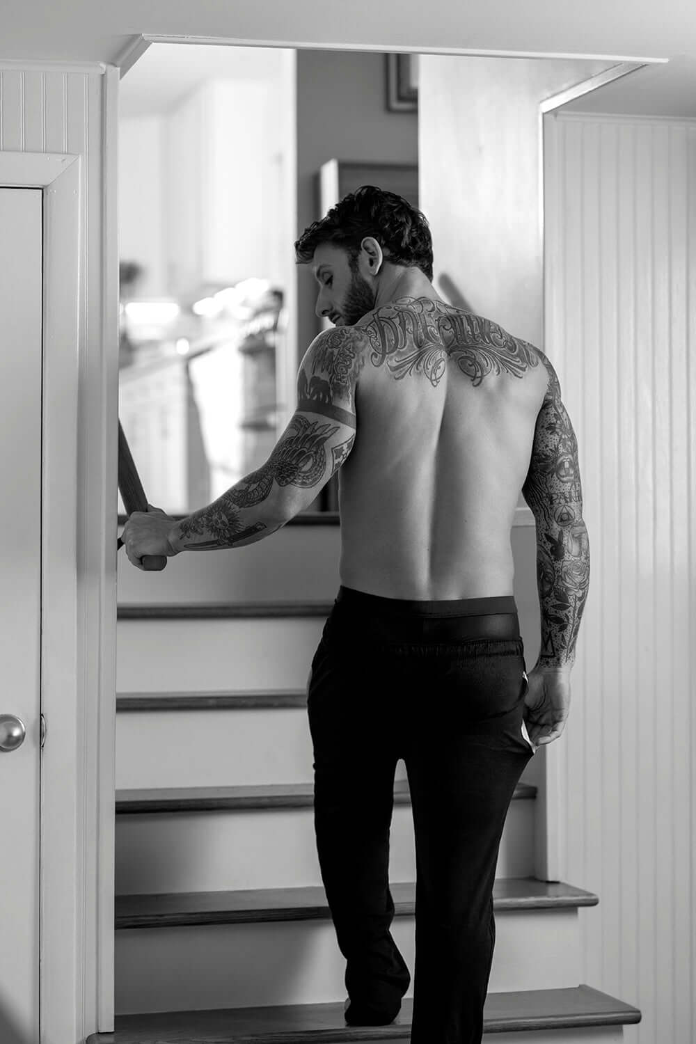 Man walking up stairs wearing Male Power Mesh 2.0 Mini Short Black L with a tattooed back.