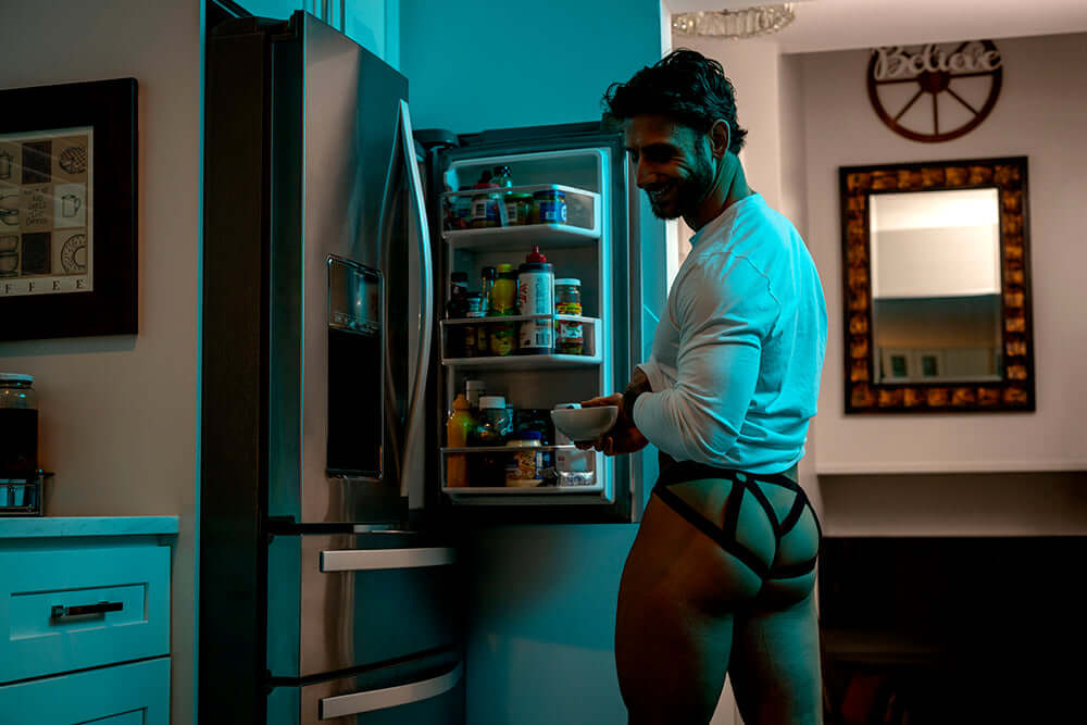 Male Power Mesh 2.0 Strappy Ring Jock Black S M shown in a modern kitchen with an open fridge at night.