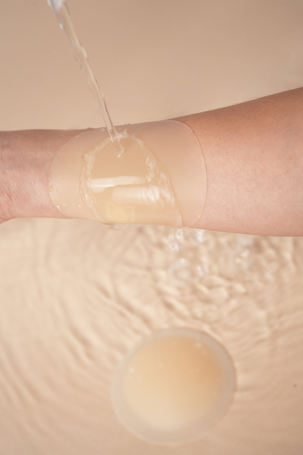 UVA Circular Nipple Covers Cocoa demonstrating waterproof capability on skin.