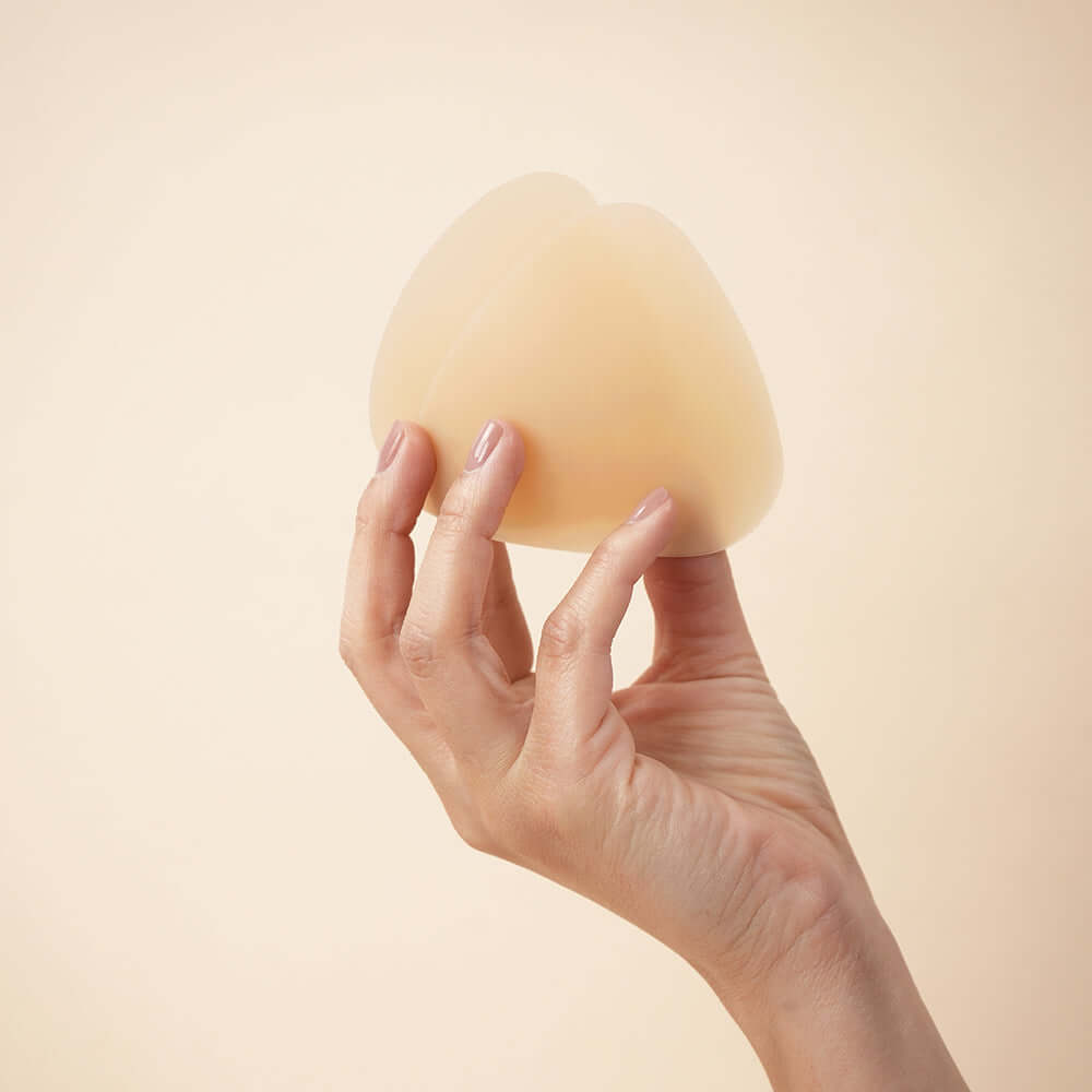 Uva Triangular Nipple Covers Caramel held in hand, showcasing smooth self-adhesive design for discreet coverage.