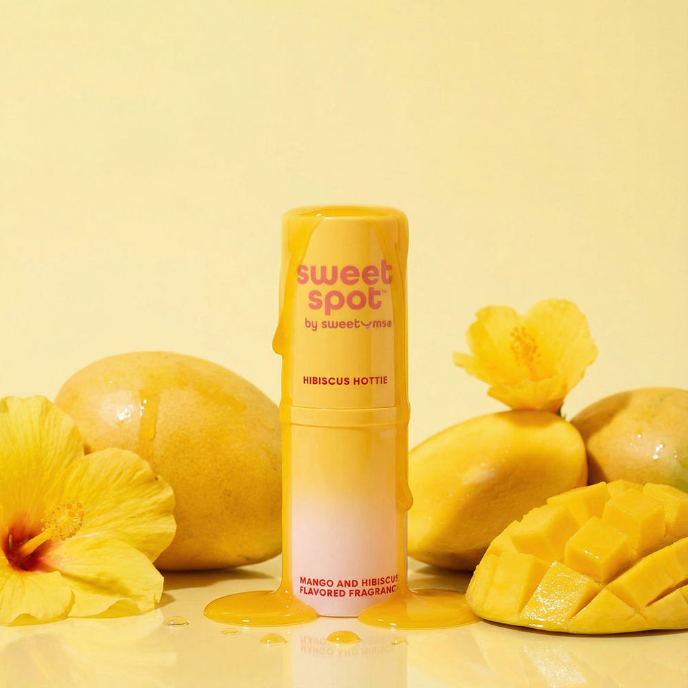 Sweetums Sweet Spot Flavored Fragrance Hibiscus Hottie with mango and hibiscus against a bright yellow background.