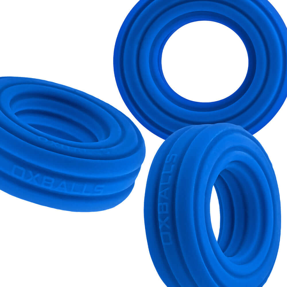 Oxballs Hunkyjunk Roto Grooved Gripper-ribbed Cockring Teal Fizz displayed in three views, showcasing its blue silicone design.