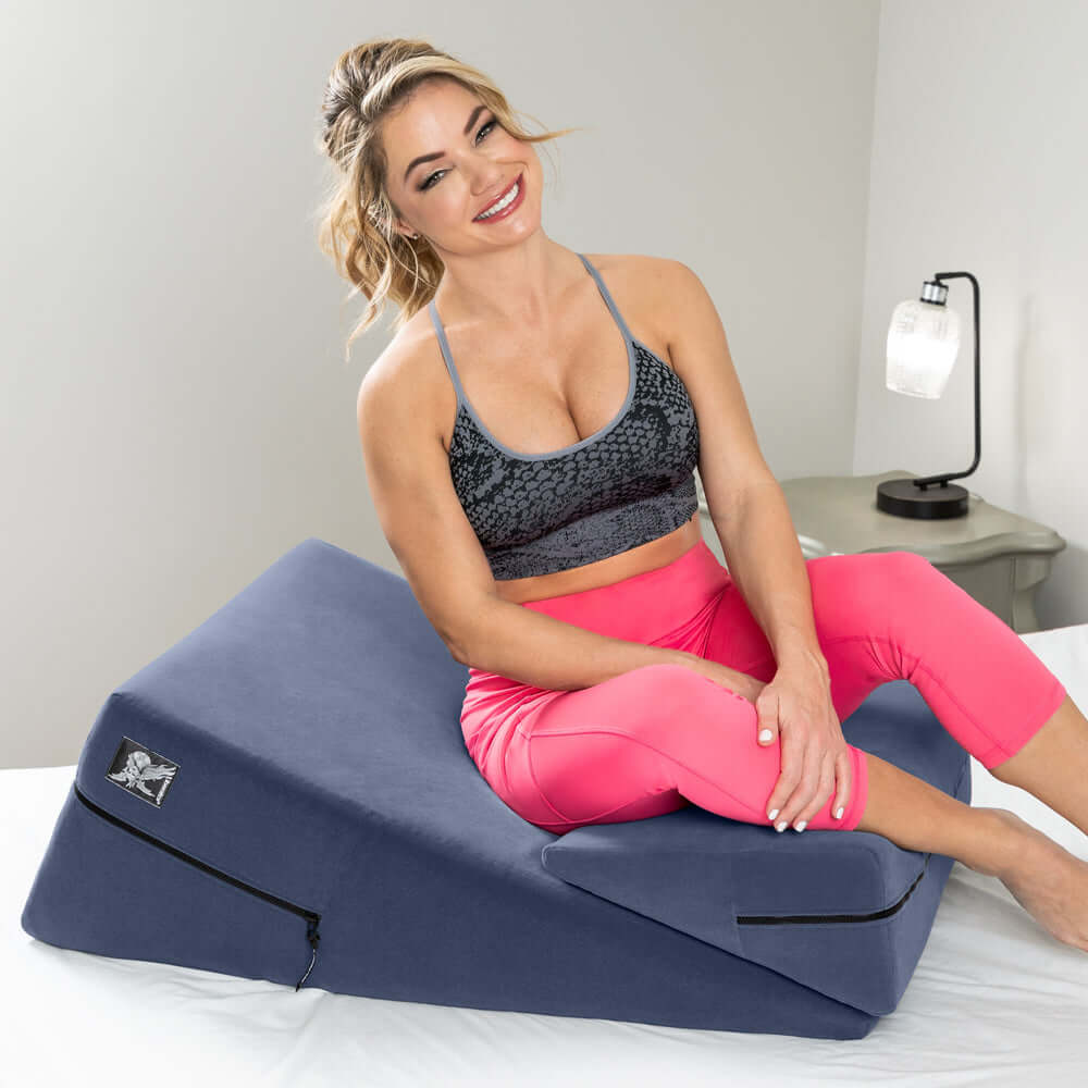 Liberator Wedge & Ramp Sex Combo Original Size Blue being demonstrated by a smiling woman in activewear.