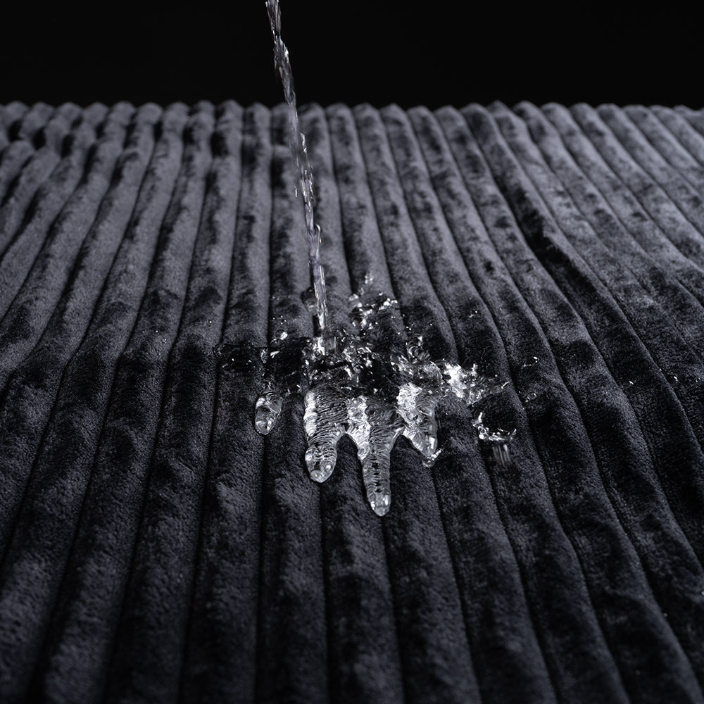 Water splashing on the plush texture of the Sportsheets Signature Waterproof Blanket.