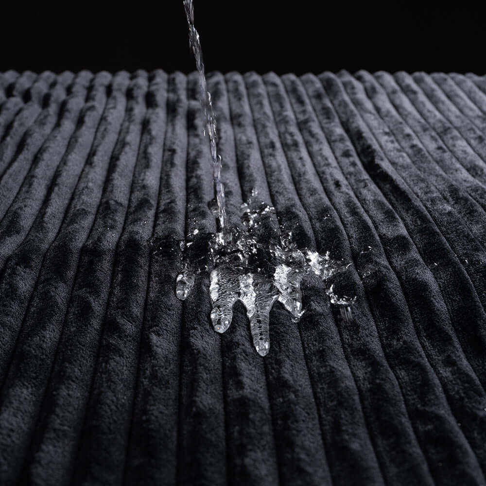 Water splashing on the plush texture of the Sportsheets Signature Waterproof Blanket.
