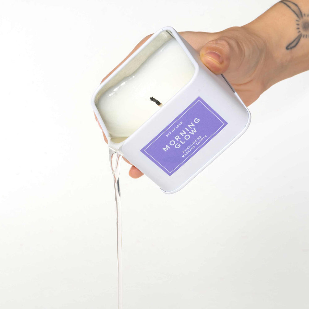 Eye of Love Morning Glow Attract Him Pheromone Massage Candle being poured from a stylish container.