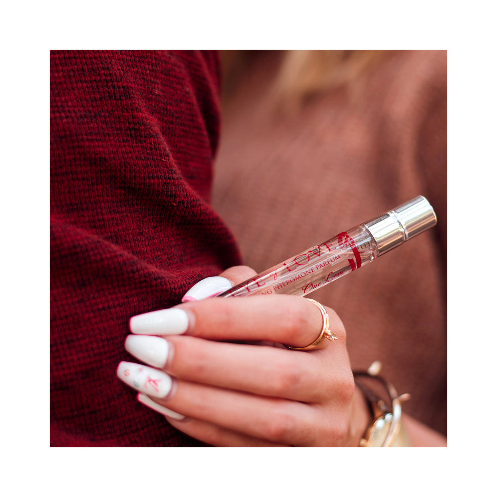 Eye of Love One Love Attract Him Pheromone Parfum 10 ml held in a woman's hand with stylish nails.