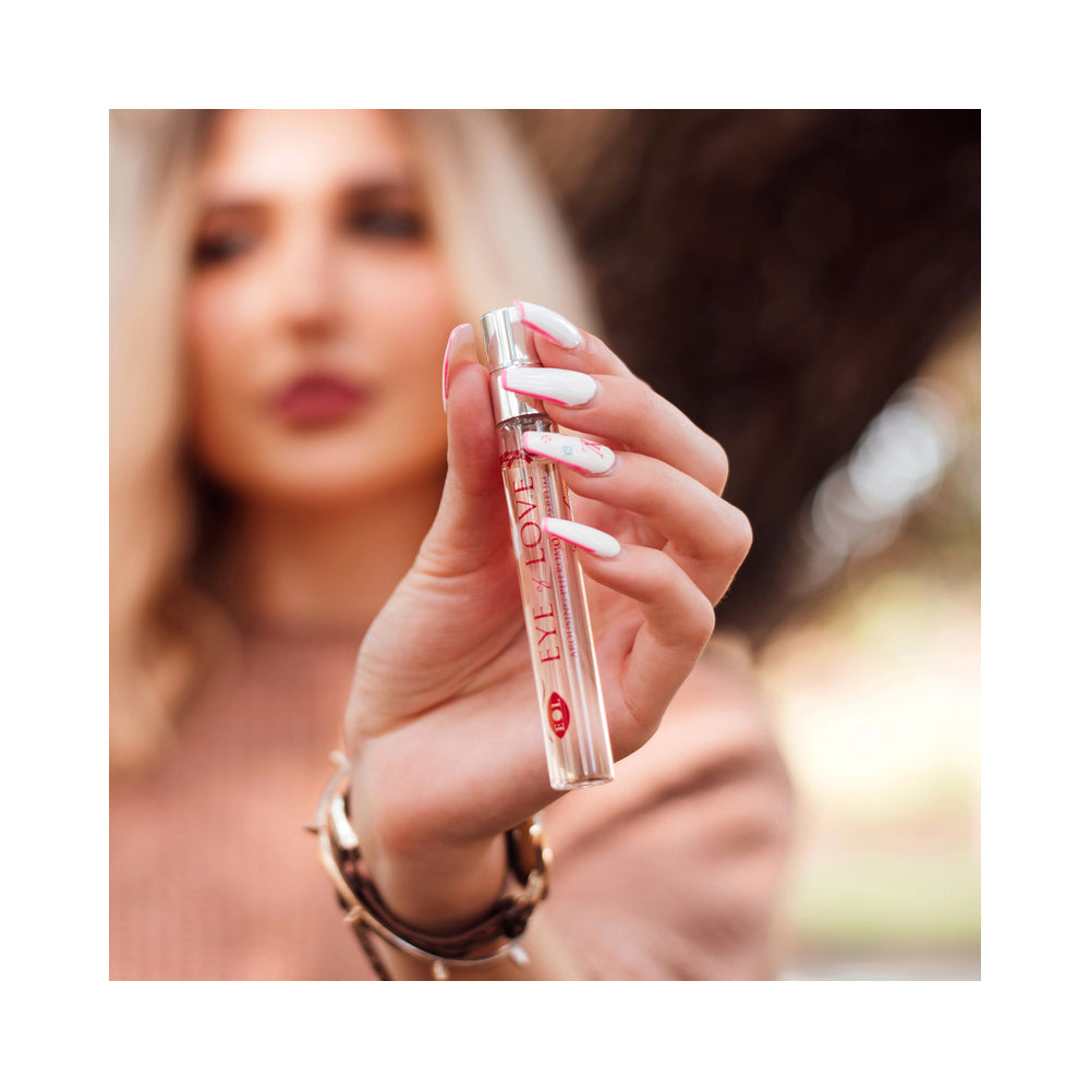 Eye of Love One Love Attract Him Pheromone Parfum 10 ml held by a woman with stylish nails outdoors.