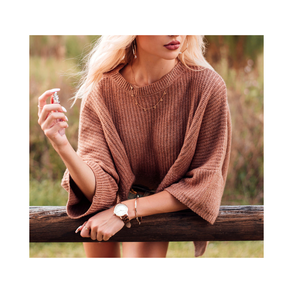 Eye of Love One Love Attract Him Pheromone Parfum 10 ml held by a woman in a cozy sweater.