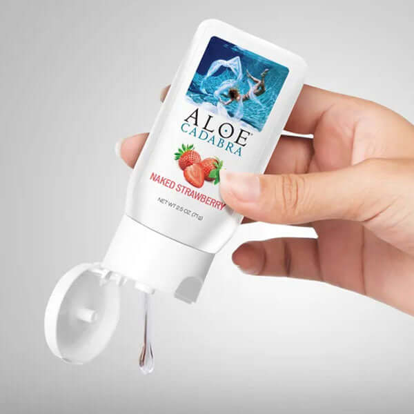 Aloe Cadabra Organic Lubricant Strawberry 2.5 Oz squeezed from a bottle held in hand.