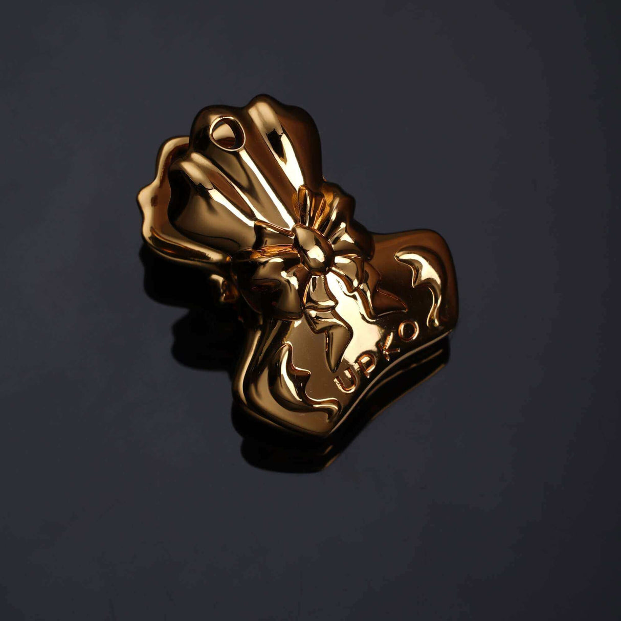 Bowknot binder clip style nipple clamp in gold, featuring an elegant shell design and embossed detailing.