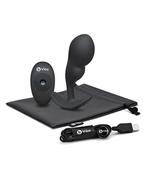 b-Vibe Remote Control P-Spot Snug Plug Black with remote and USB charging cable on storage pouch.
