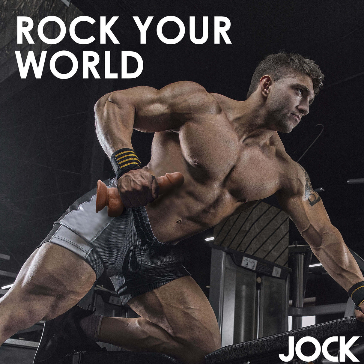 Muscular man lifting weights in a gym, promoting the Jock Weightlifting Wesley 7 Inch Dildo.