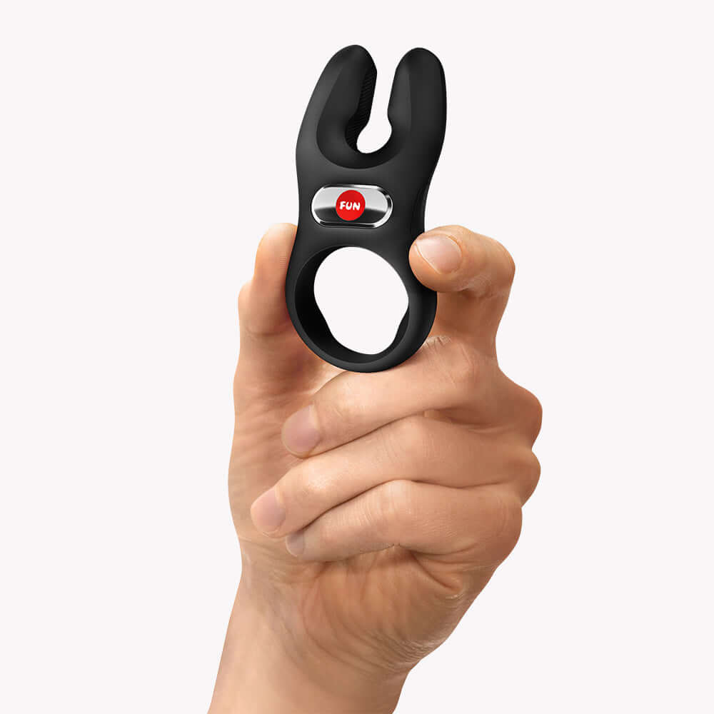 NOS Classic Vibrating Cock Ring Black held in hand with button for easy control and maximum pleasure.