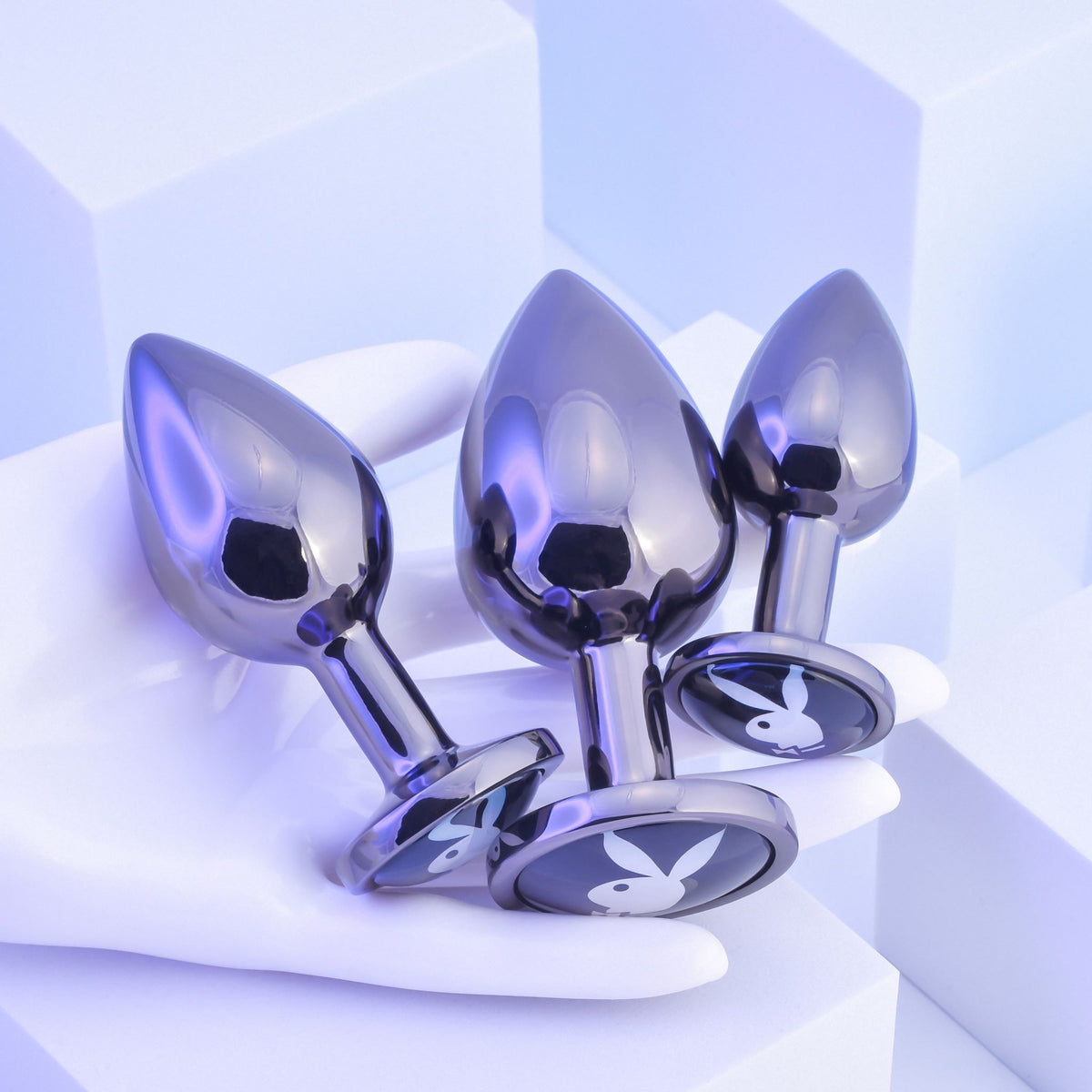Playboy Pleasure 3 Ways Metal Anal Training Kit Black on a hand, showcasing graduated plugs for anal play.