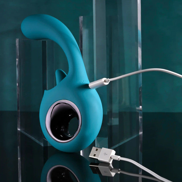 Evolved How Many Licks Silicone Vibrator Blue charging on a sleek surface, showcasing its unique design and features.