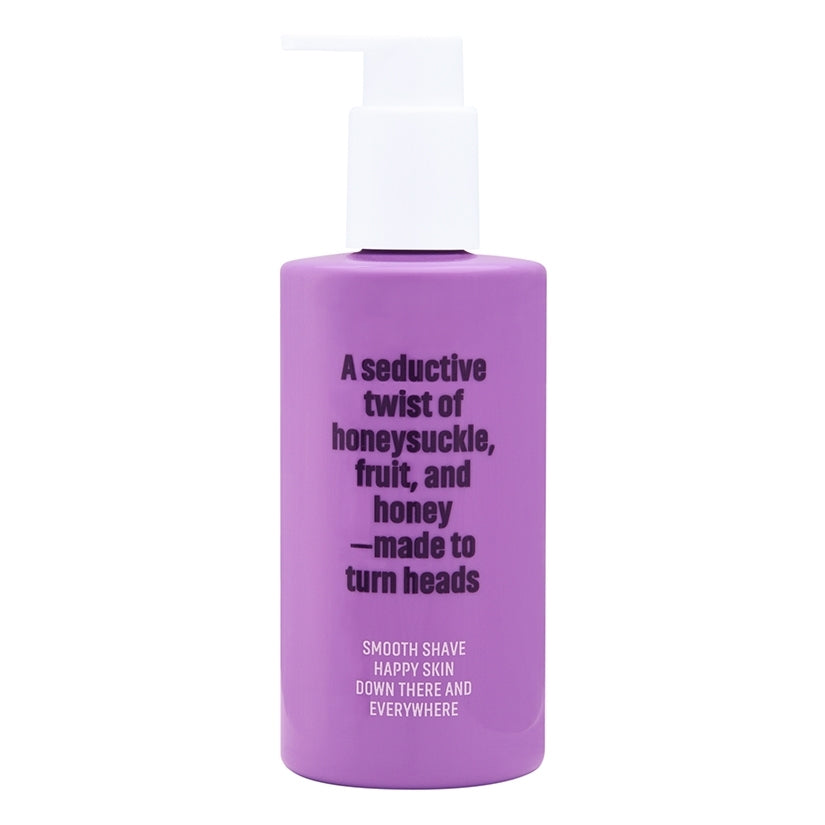 Coochy Shave Cream Flirty Blooms 8 Oz bottle featuring a glossy purple design and smooth shave promise.
