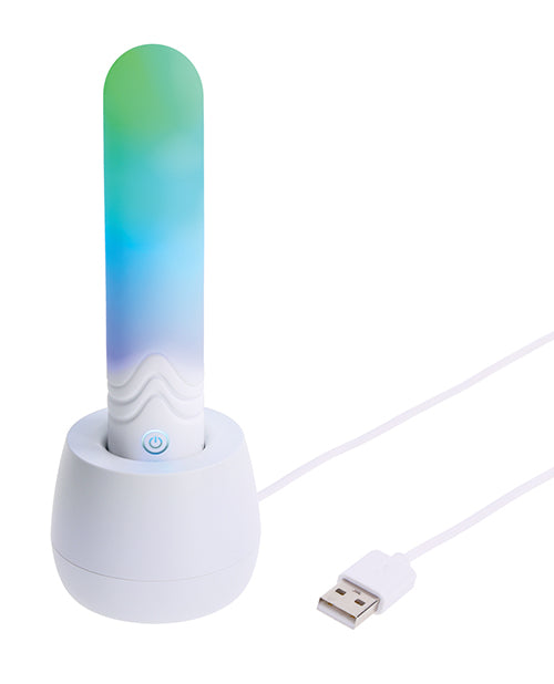 Illumination THE Bullet Vibrator White charging in white dock with colorful LED lights.