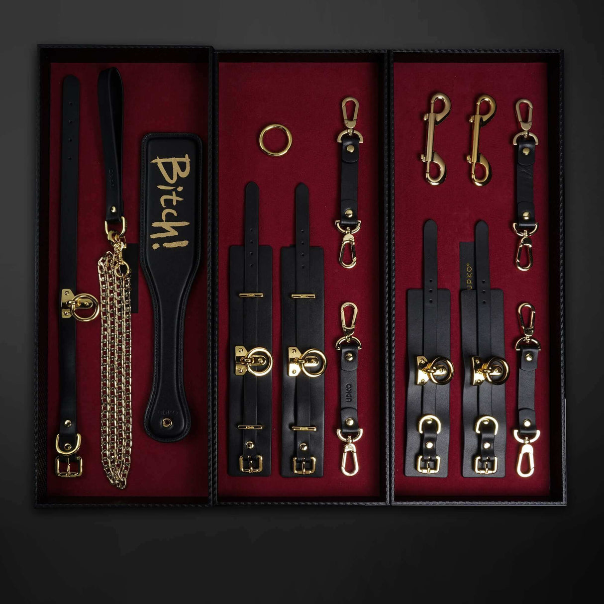 UPKO Luxury Italian Leather Bondage Tools Set displayed in a sleek black case with gold accents and red velvet interior.