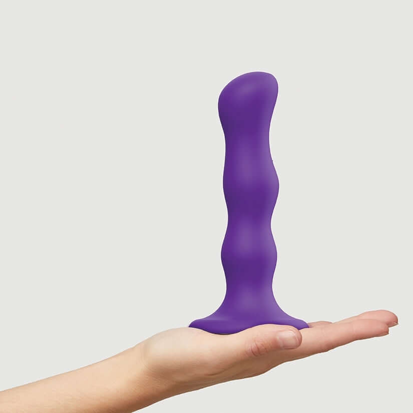 Strap On Me Geisha Dildo With Balls Purple M held in hand, showcasing its ergonomic design and soft touch.
