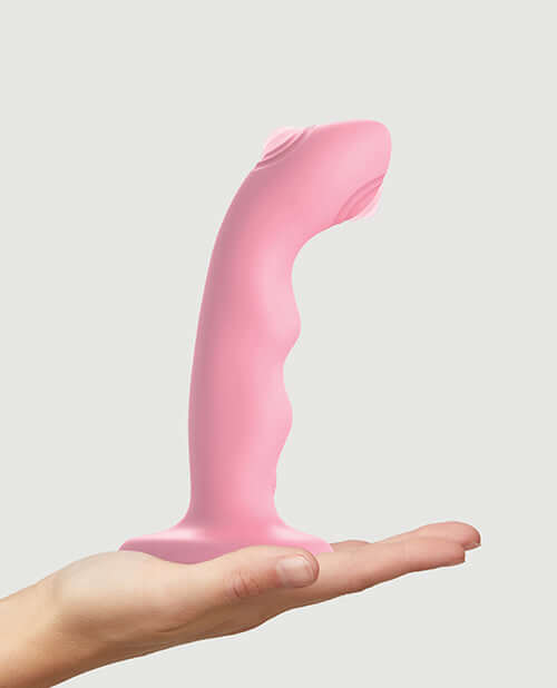 Strap-On-Me Tapping Dildo Wave Vibrator Coral displayed in a hand.
