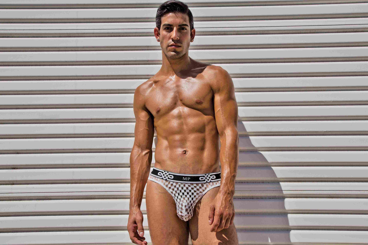 Male Power Peep Show Low Rise Thong White Small to Medium on a model showcasing a bold and revealing design.