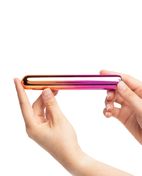 Sensuelle Aluminium Rumba Double Motor Ombre Warming Bullet held in hands, showcasing its sleek rainbow ombre design.