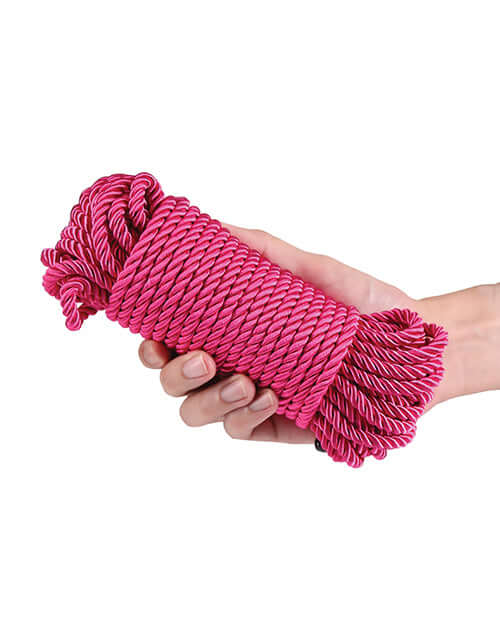Bound 50 ft Bondage Restraints Rope Pink held in hand, showcasing its soft texture and vibrant color.
