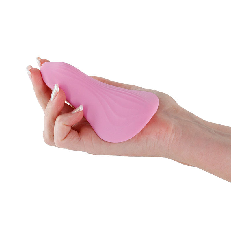 Desire Mantra Coral Dual Motor Panty Vibrator held in hand, showcasing its sleek coral pink design.