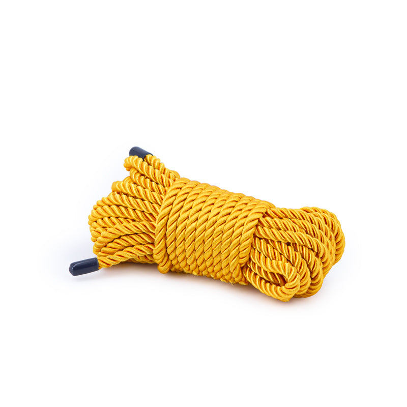 Bondage Couture 25 Feet Polyester Rope Gold displayed in a sleek, coiled form, showcasing its vibrant metallic finish.