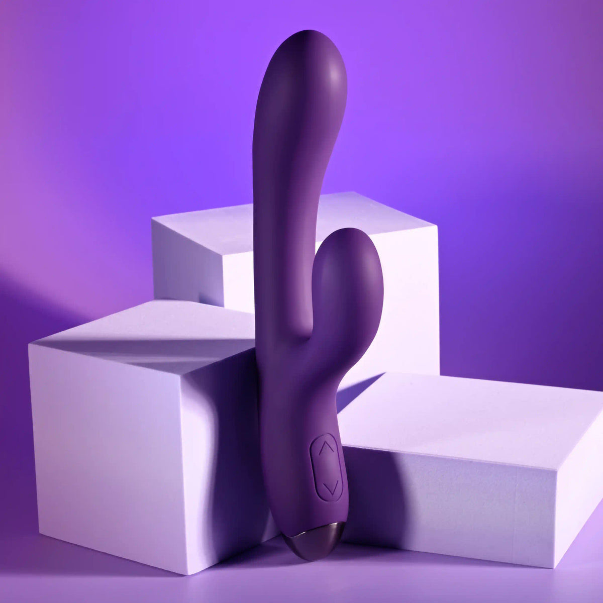 Playboy New Crush Rechargeable Dual Vibrator on white blocks with a purple background, designed for pleasure.