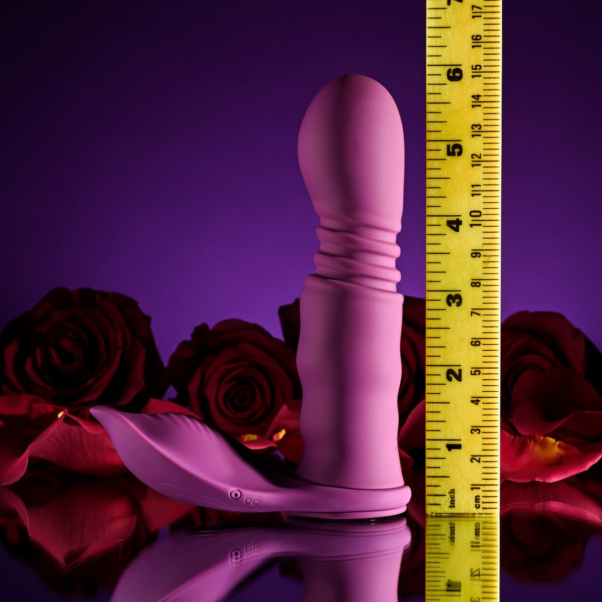 Playboy Match Play Silicone Dual Vibrator Purple alongside roses, highlighting its sleek design and versatility.