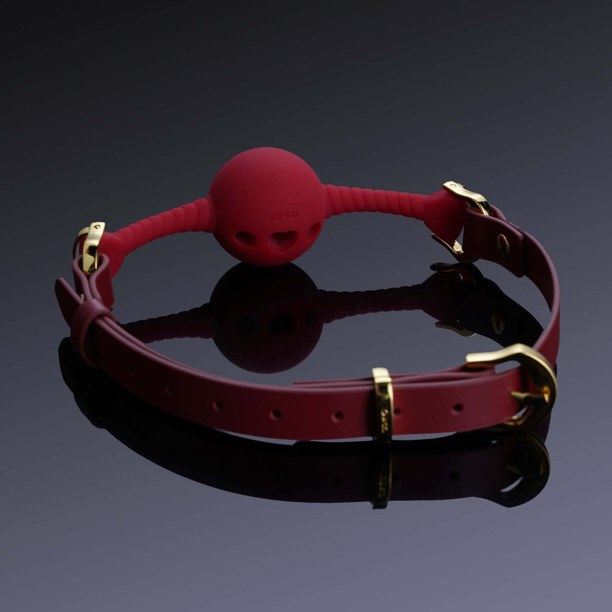 Red heart-shaped silicone mouth gag with gold hardware and adjustable Italian leather strap for comfort and style.