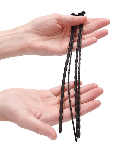 Spiral Screw Plug Set Beginner Urethral Sounding Black displayed in hands showing smooth design and texture.