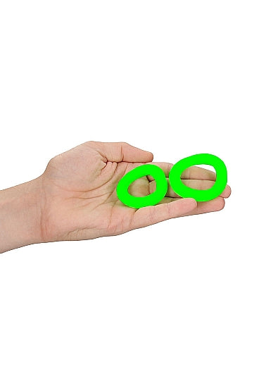 Glow 2pcs Cock Ring Set Glow In The Dark held in a hand, showcasing green luminous rings.