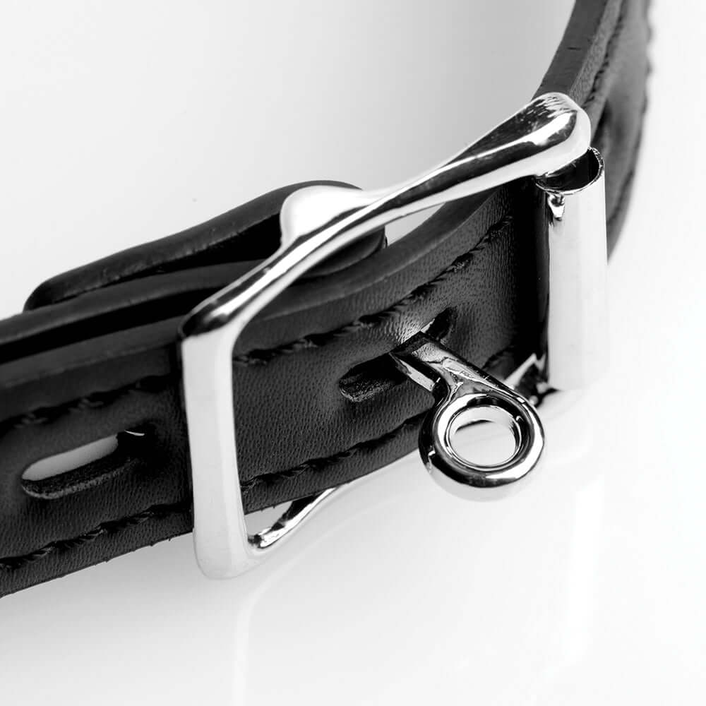 Close-up of a black leather strap with a silver buckle and locking ring, ideal for a mouth spreader.