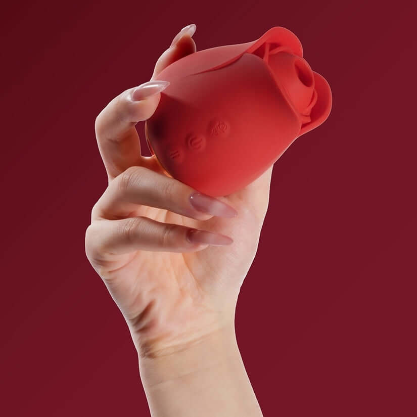 Hand holding the Tracys Dog Rosie Air Suction Massager in a rose design, showcasing its compact and powerful features.