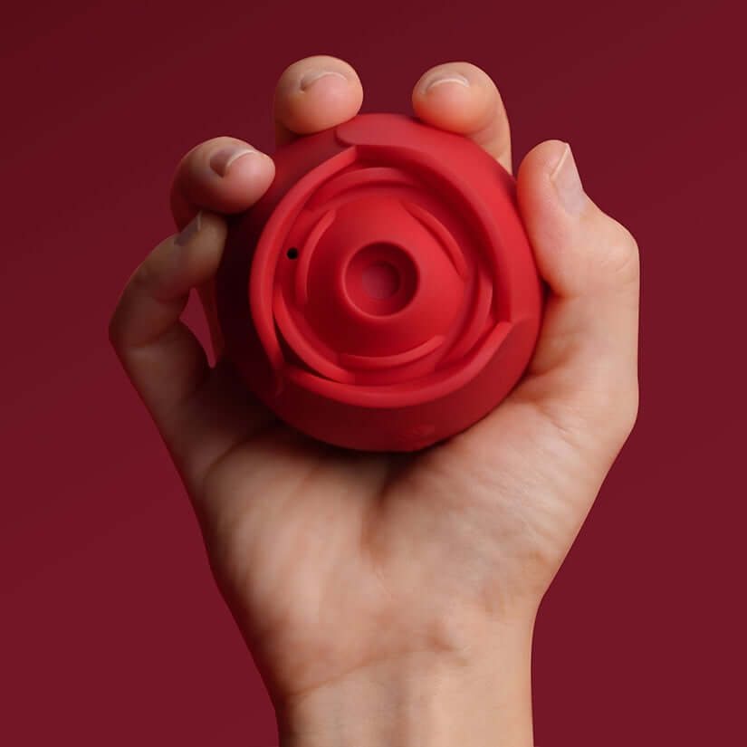 Hand holding the Tracys Dog Rosie Air Suction Massager, showcasing its rose-inspired design.