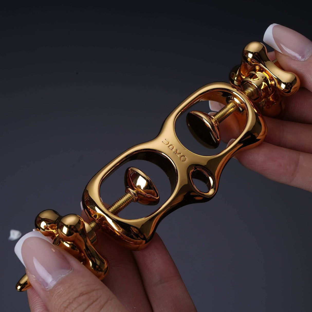 UPKO Thumb Metal Cuffs in gold, showcasing the unique design and pull string mechanism for secure restraint.
