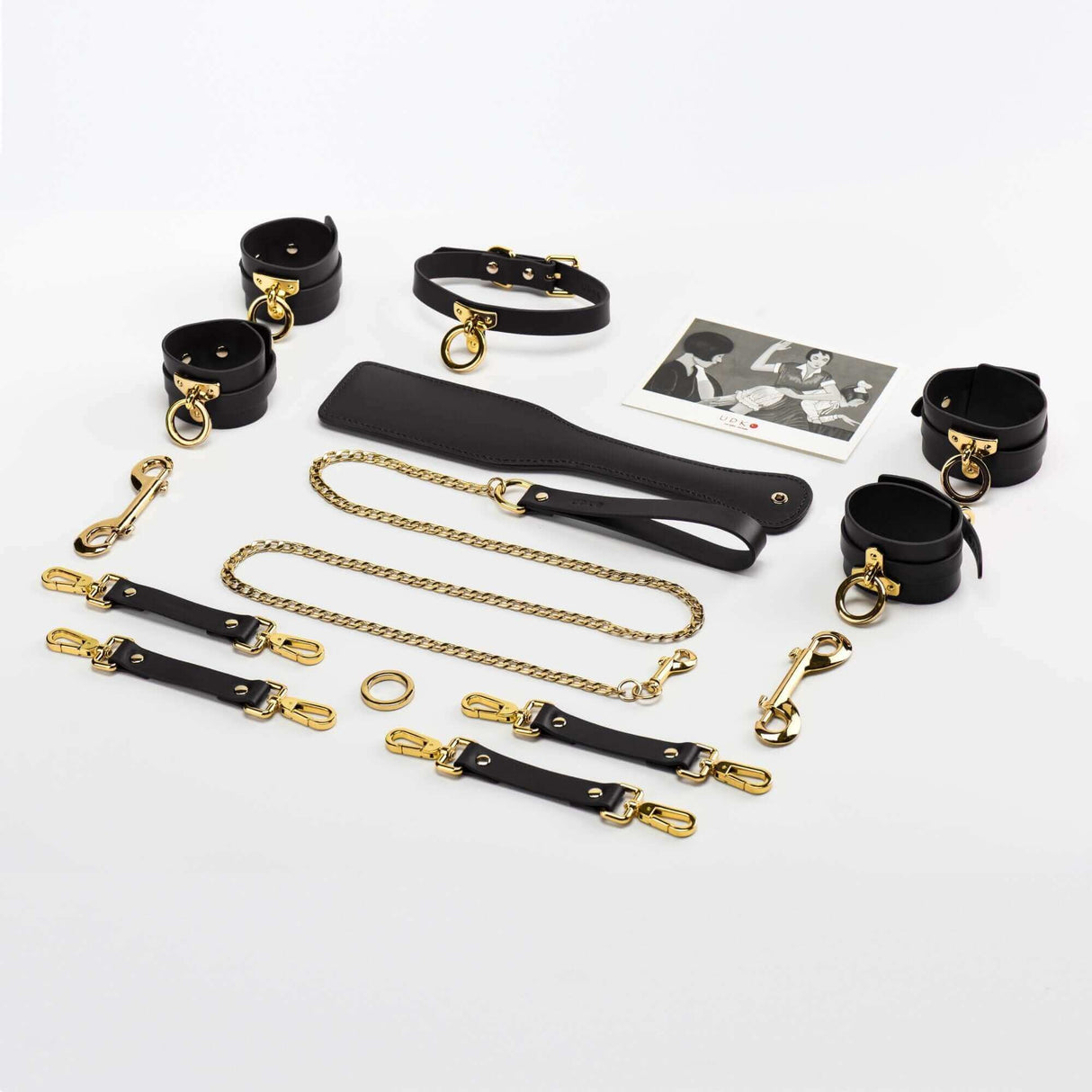 UPKO luxury Italian leather bondage tools set with gold accents, including collars, cuffs, leash, and accessories in a stylish arrangement.