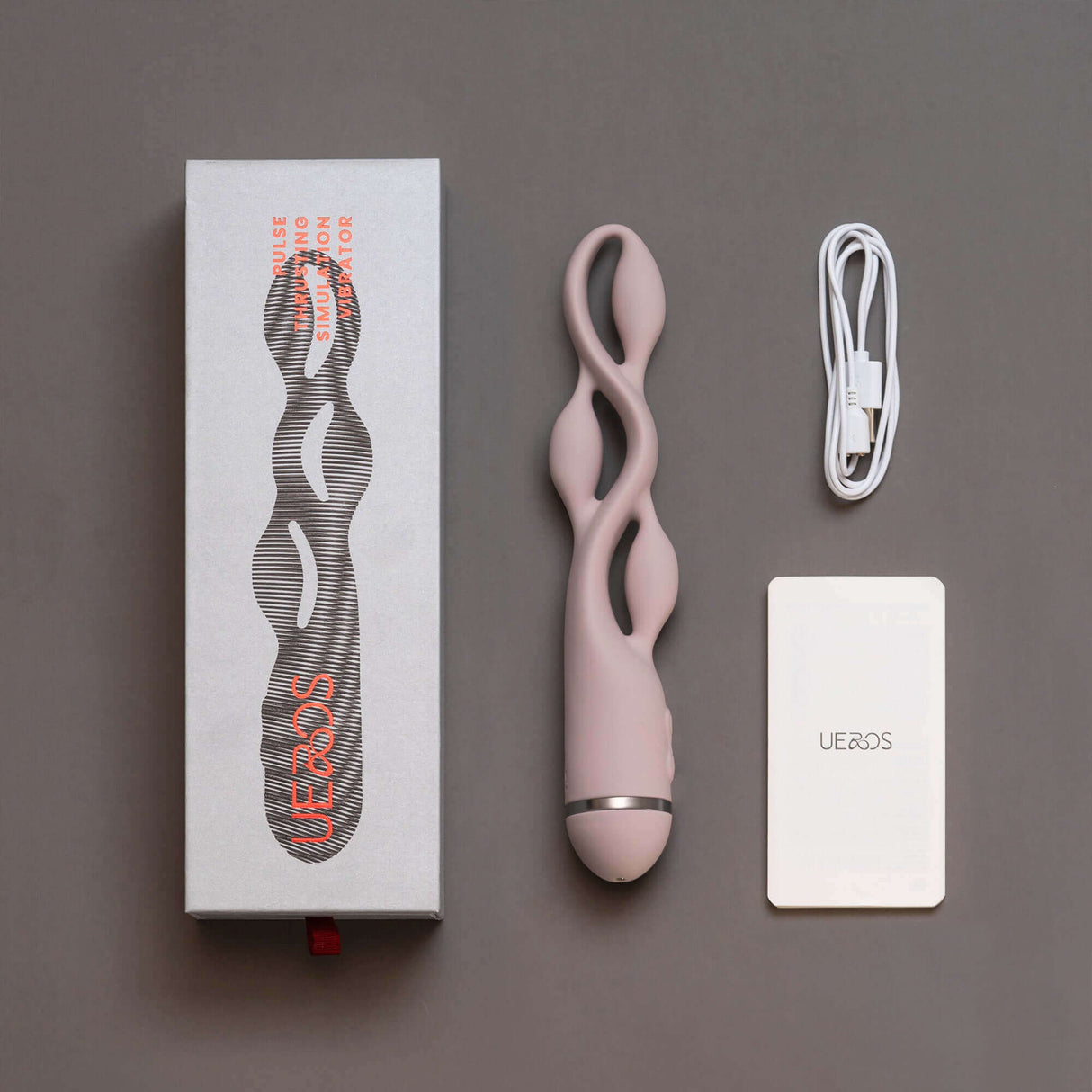 UEROS pink multi-motor pulse vibrator with unique design, packaging box, charging cable, and instruction manual displayed.