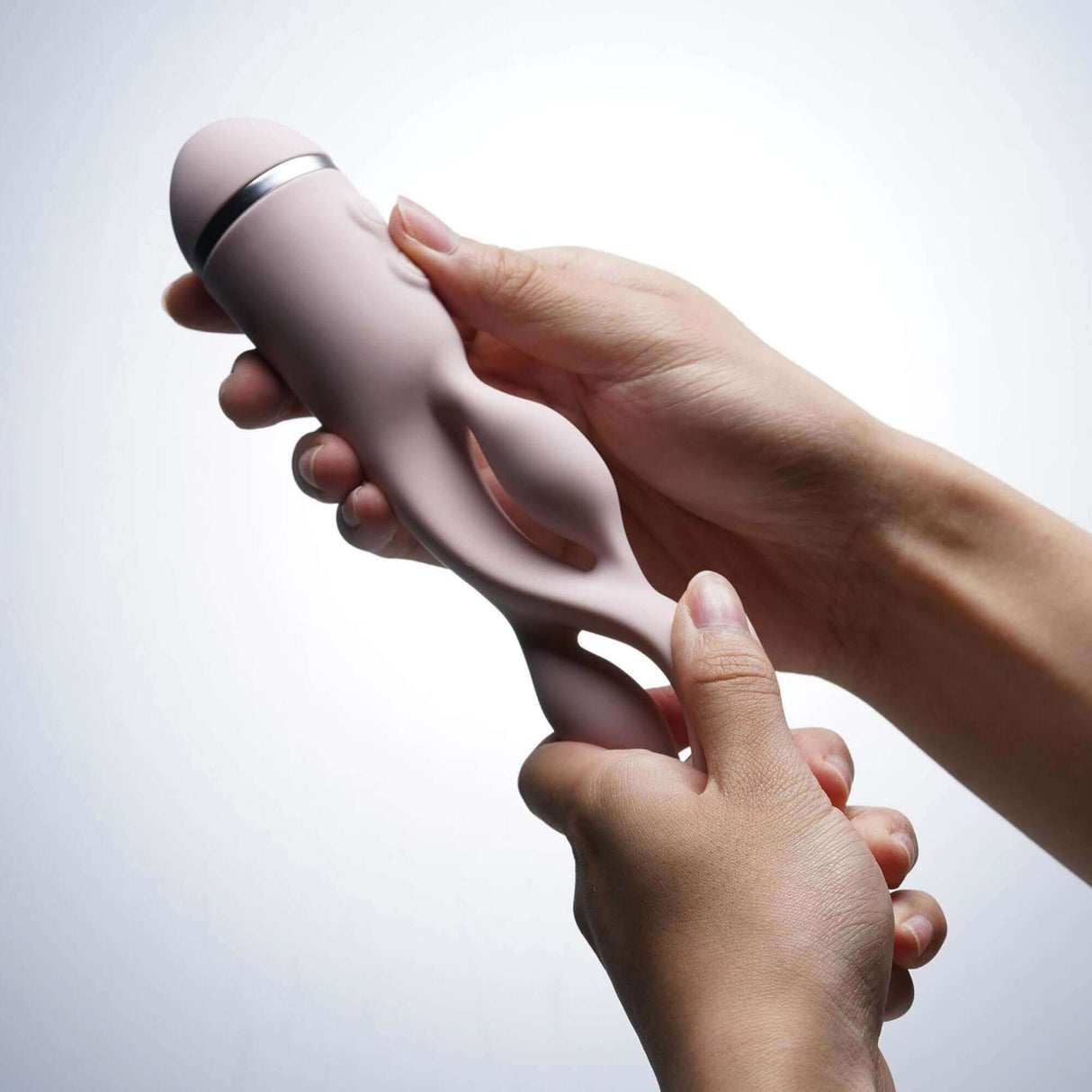 Person holding UEROS Multi-motor Pulse Vibrator in pink, showcasing its unique design and versatility.