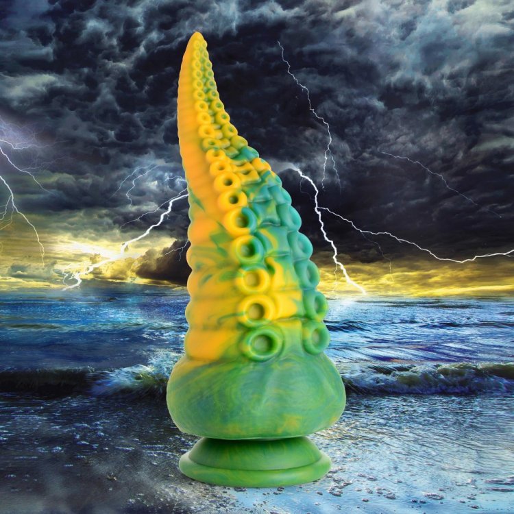 Creature Cocks Monstropus Tentacled Monster Dildo in marbled green, yellow, and blue against a stormy ocean backdrop.