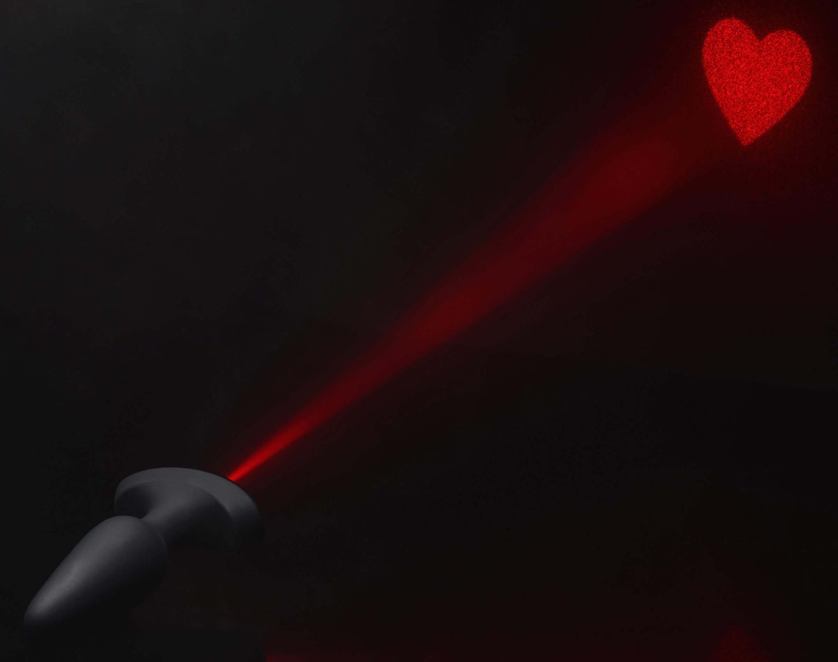 28X Laser Heart Silicone Anal Plug with Remote Large projecting a bright red heart.