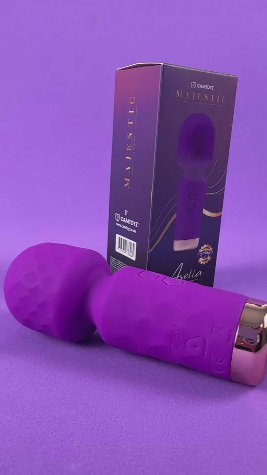 Camtoyz Majestic Aselia Mini Wand Vibrator on display with packaging against a purple background.